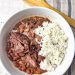 Slow Cooker Red Beans served in a white bowl garnished with fresh herbs and a side of rice, illustrating the final delicious meal made from the recipe.